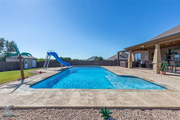 a view of a house with a yard and furniture