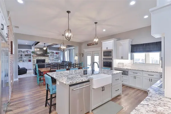 a large kitchen with kitchen island a sink table and chairs