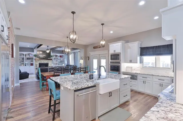 a large kitchen with kitchen island a sink table and chairs