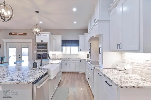 a large kitchen with granite countertop lots of counter space sink and refrigerator