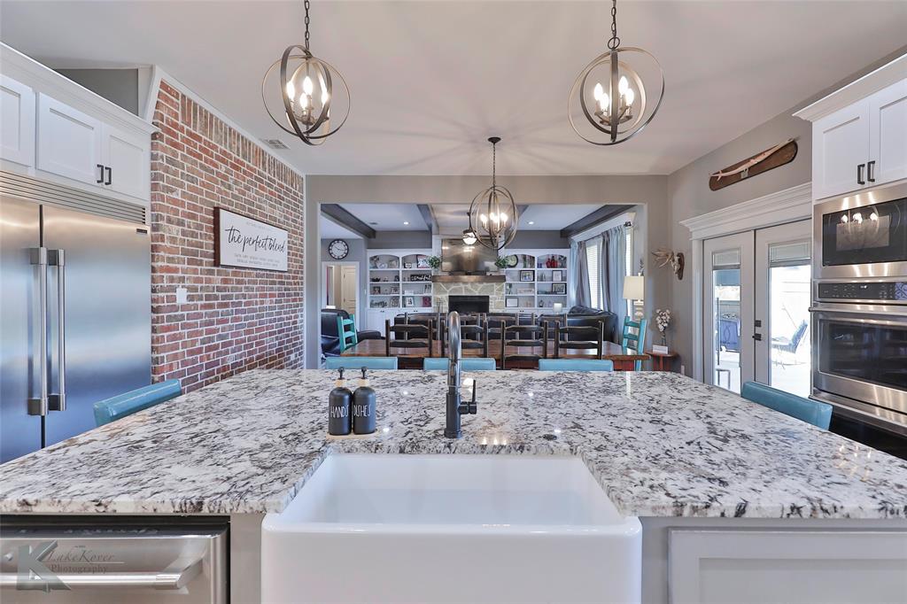 125 Wallace Court Tuscola, TX 79562 - Photo 10 of 40 a kitchen with stainless steel appliances granite countertop a sink a refrigerator and wooden cabinets