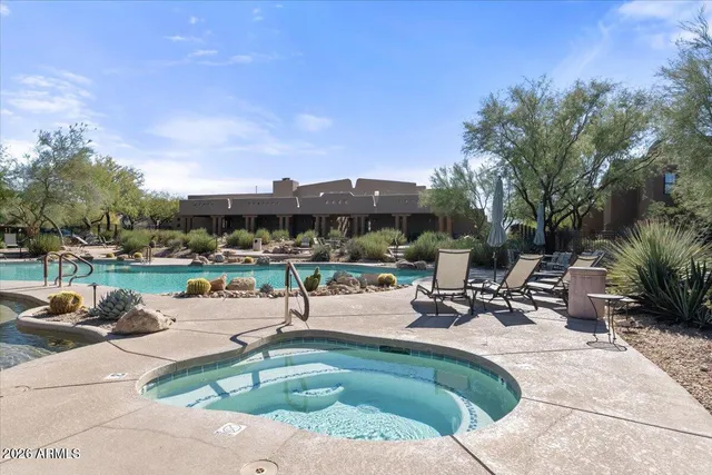 a view of a swimming pool with lawn chairs and a fire pit
