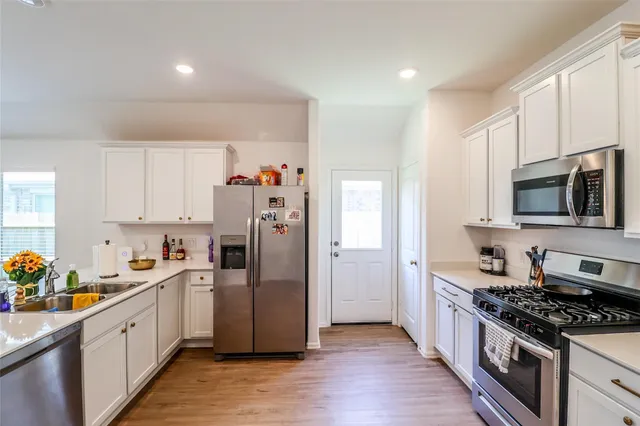 a kitchen with stainless steel appliances a refrigerator stove and sink