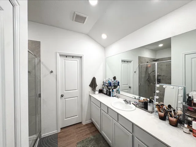 a bathroom with double vanity sinks a large mirror and a shower