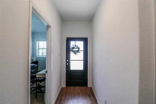 a view of a hallway with wooden floor and closet