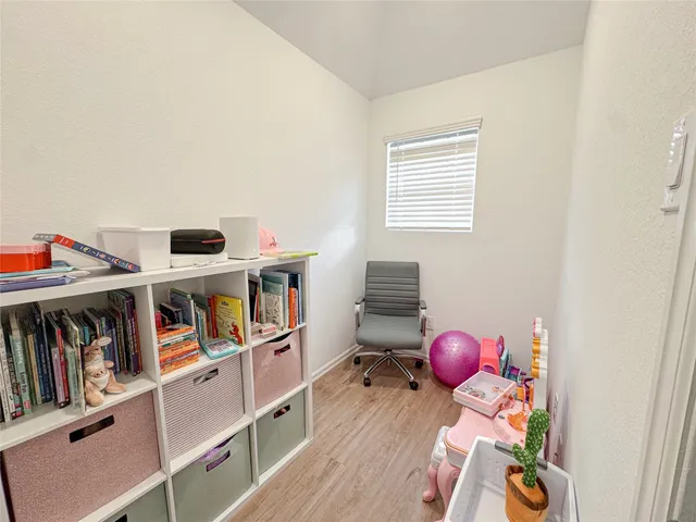 a living room with furniture a bookshelf and a window