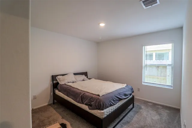 a bed sitting in a bedroom next to a window