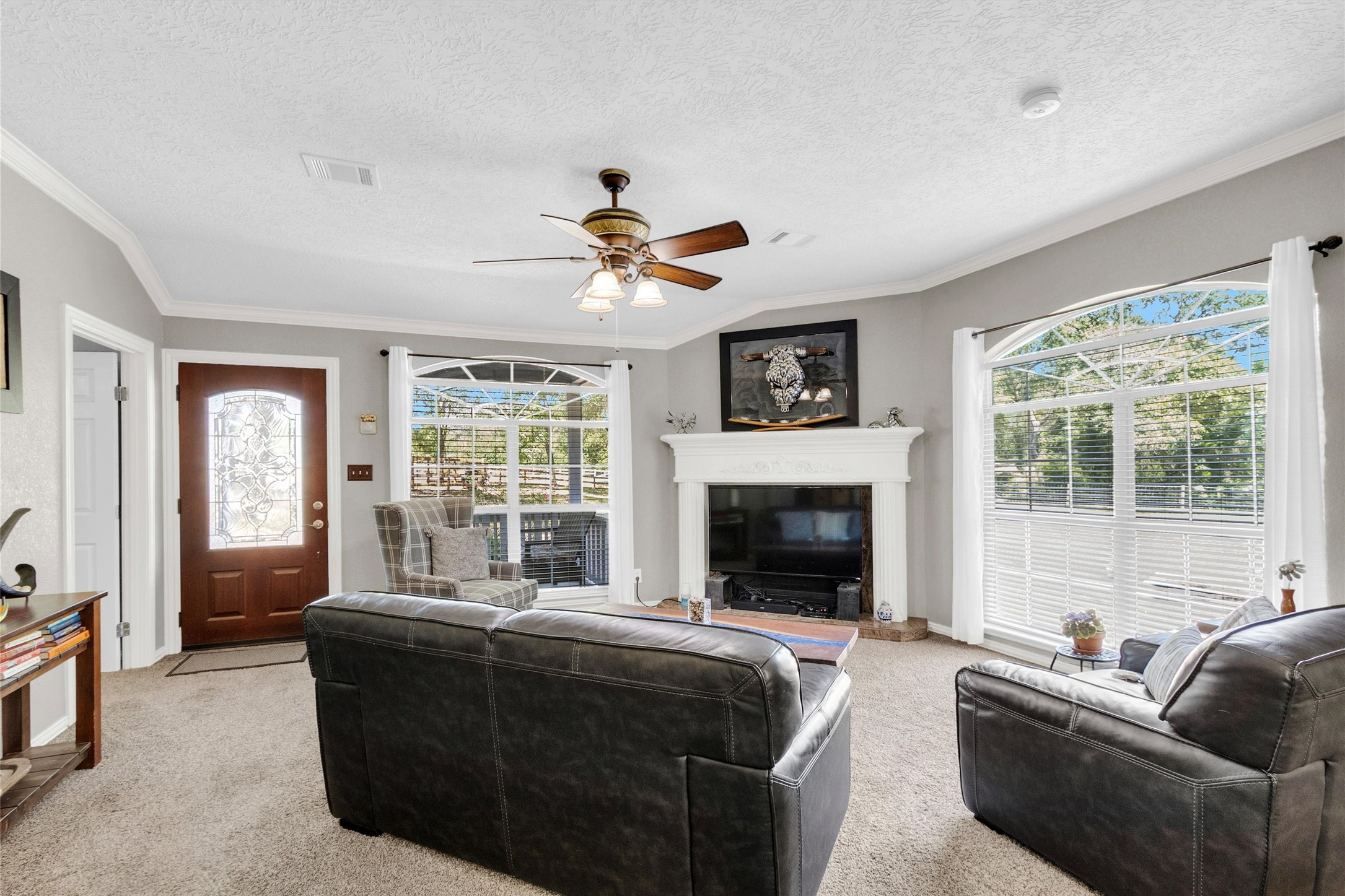 38805 Wyatt Chapel Road Hempstead, TX 77445 - Photo 8 of 50 The living room features a fireplace and large windows that let in ample natural light.