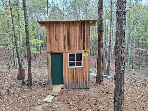 a view of a house with a backyard and trees