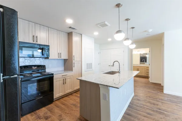 a kitchen with stainless steel appliances granite countertop a sink a refrigerator and a stove