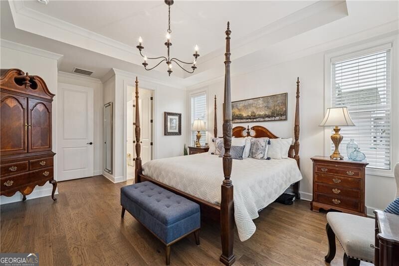 103 Rabun Court Hoschton, GA 30548 - Photo 11 of 22 a bedroom with a bed chandelier and a window