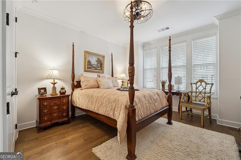 103 Rabun Court Hoschton, GA 30548 - Photo 14 of 22 a bedroom with a bed and a chandelier