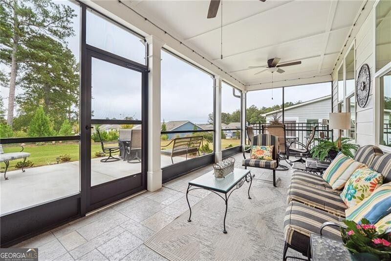 103 Rabun Court Hoschton, GA 30548 - Photo 18 of 22 a living room with patio furniture and a floor to ceiling window