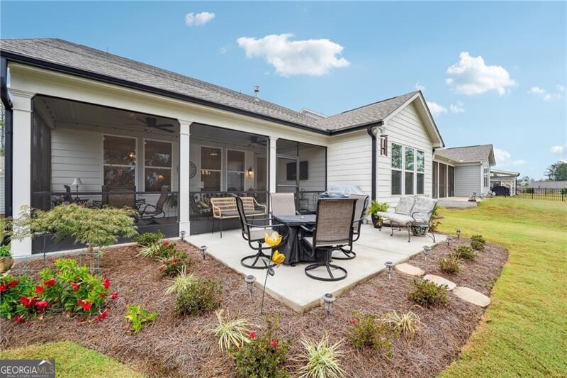 103 Rabun Court Hoschton, GA 30548 - Photo 19 of 22 a view of a backyard with sitting area and garden