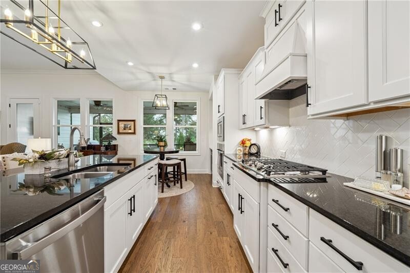 103 Rabun Court Hoschton, GA 30548 - Photo 8 of 22 a kitchen with granite countertop a sink stove and cabinets