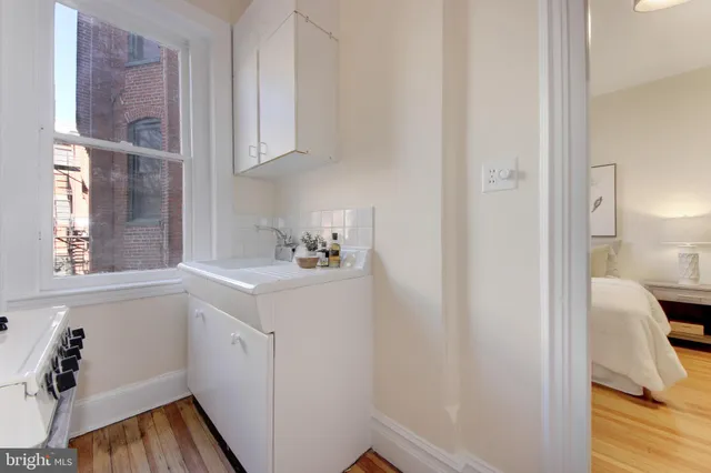 a kitchen with a refrigerator and a wooden floor