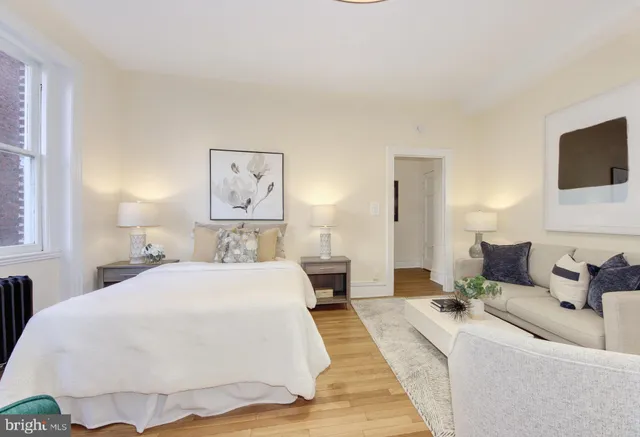 a spacious bedroom with a bed and a flat screen tv