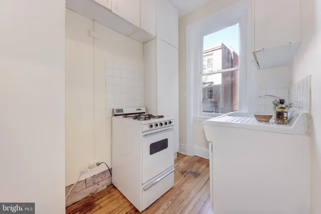 a view of hallway with sink and wooden floor