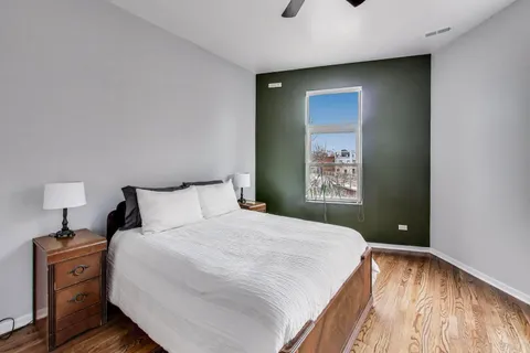 a bedroom with a bed and a lamp on dresser