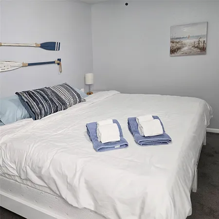 a bedroom with a bed and painting on the wall