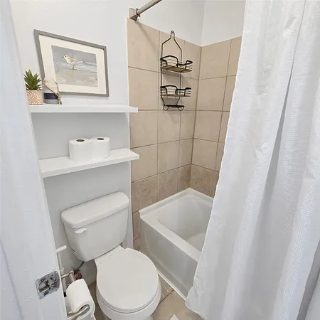 a white toilet sitting next to a bath tub