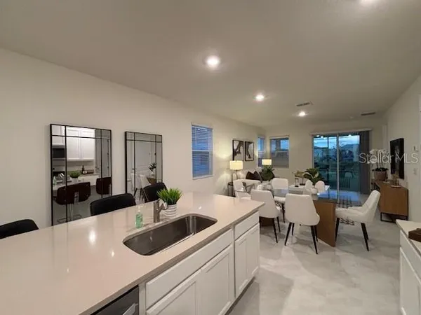 a kitchen with a sink a counter and chairs