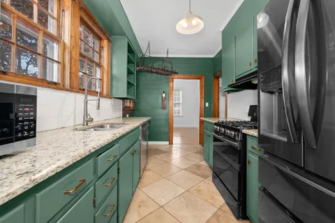 a kitchen with stainless steel appliances granite countertop a sink and a stove