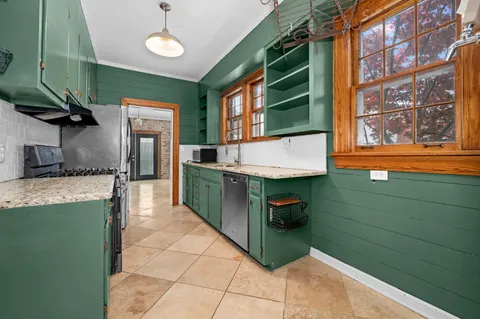 a kitchen with stainless steel appliances granite countertop a sink and a refrigerator