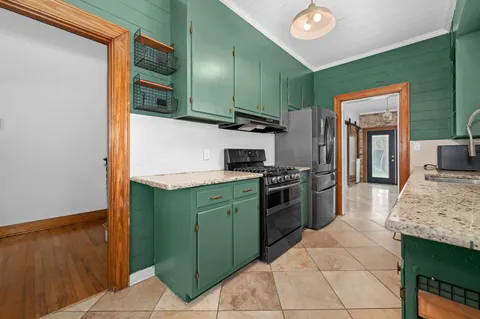 a kitchen with stainless steel appliances granite countertop a refrigerator and a stove top oven