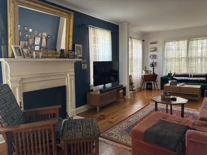 a living room with furniture a fireplace and large window