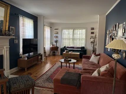 a living room with furniture a flat screen tv and a window