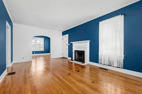 a view of empty room with wooden floor and fireplace