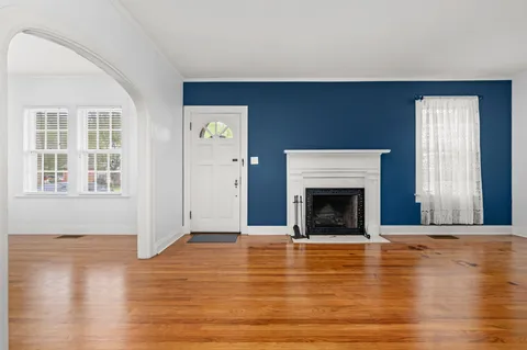 a view of a livingroom with wooden floor and a fireplace