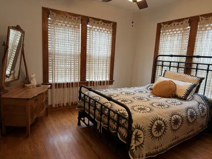 a bedroom with a bed and wooden floor