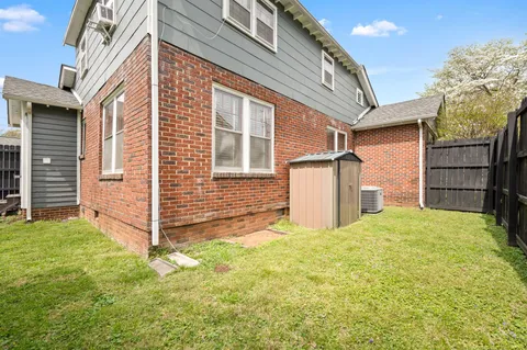 a view of a house with backyard and a tree