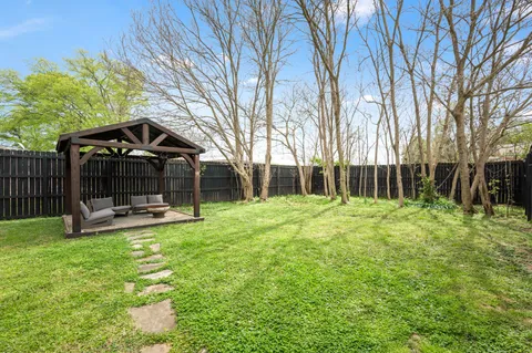 a view of a patio with a table chairs and a backyard