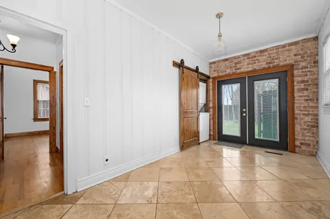 a view of a hallway with closet and a chandelier