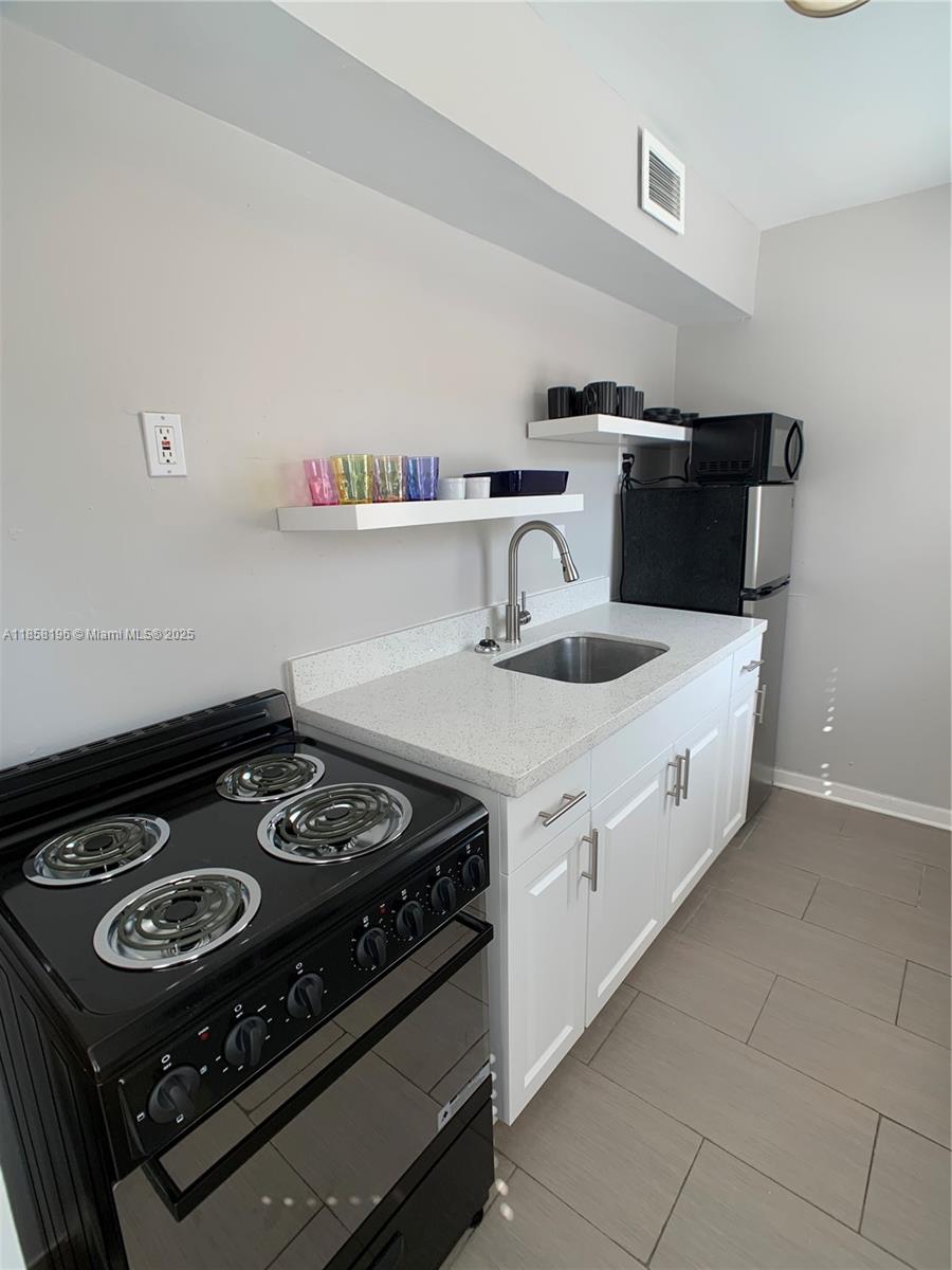 1308 Drexel Avenue, Unit 105 Miami Beach, FL 33139 - Photo 19 of 24 a kitchen with a stove and a sink