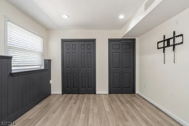 a view of an empty room with closet and a window