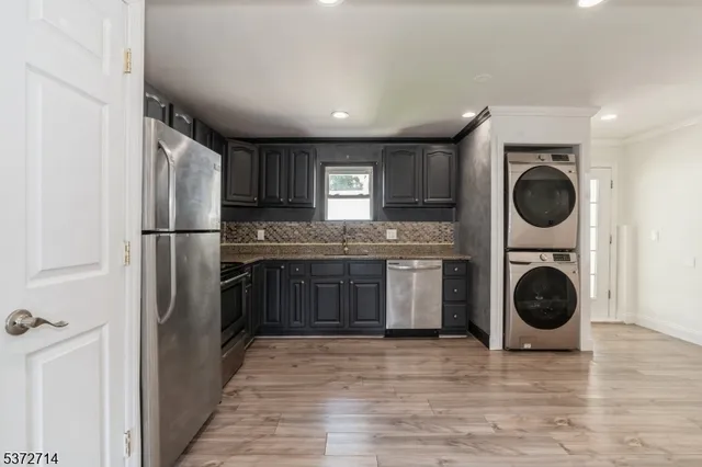 a kitchen with stainless steel appliances granite countertop a refrigerator and a stove top oven