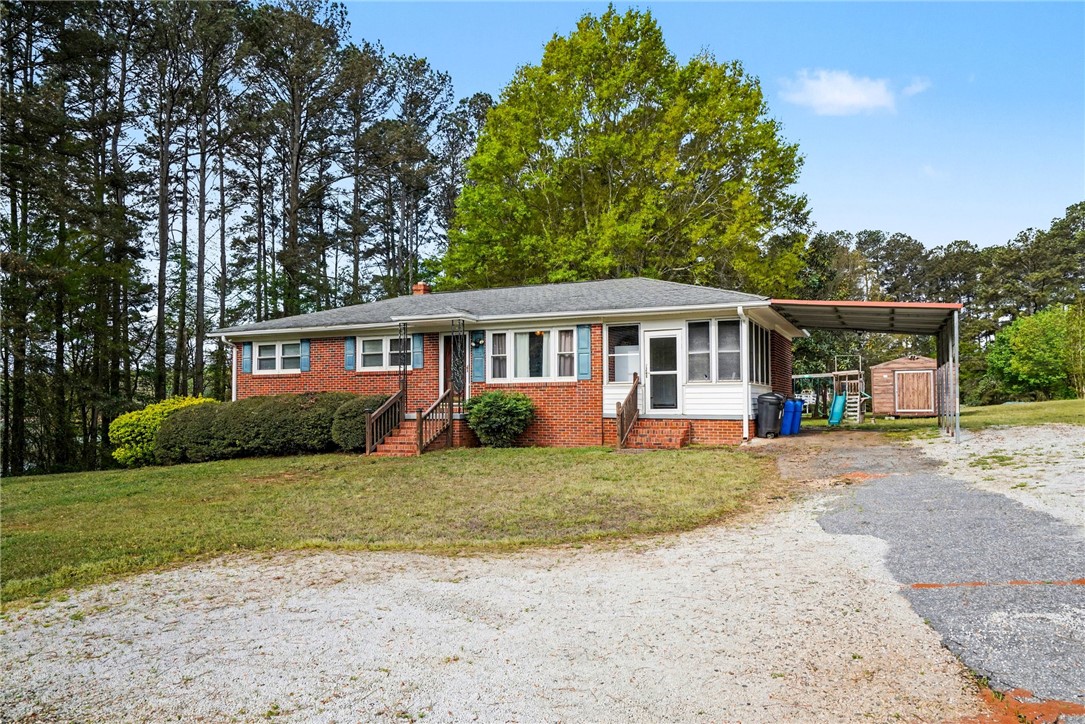 798 Coneross Creek Road Seneca, SC 29678 - Photo 2 of 34 This charming home offers a welcoming facade with a convenient carport and lush surrounding greenery.