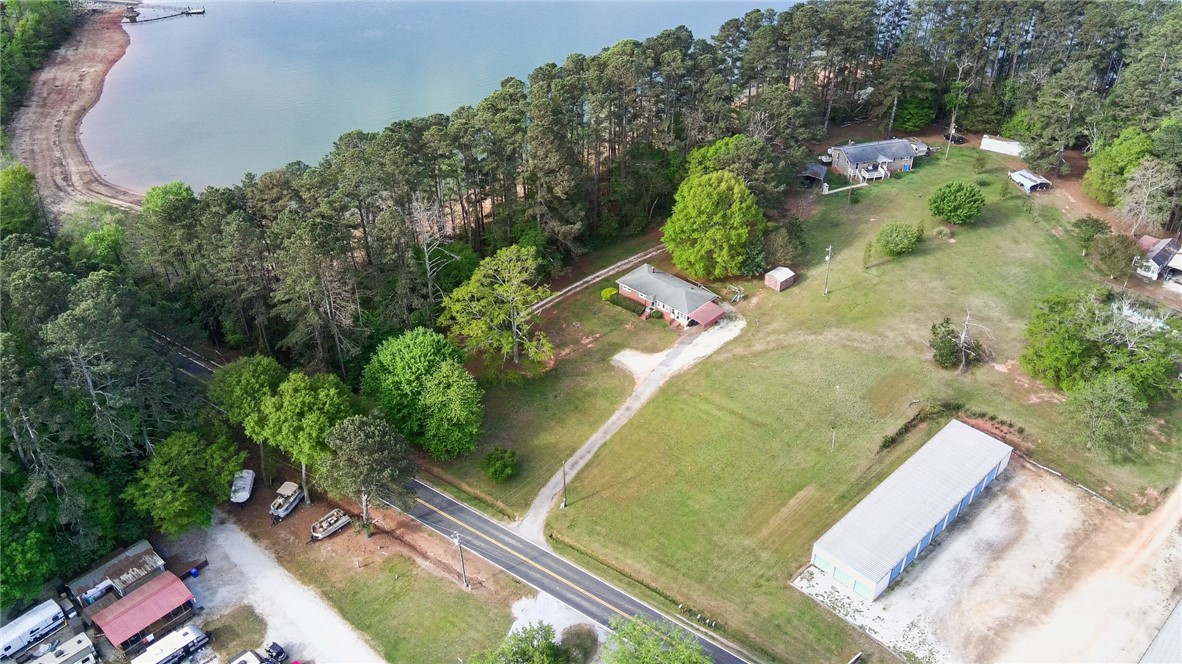 798 Coneross Creek Road Seneca, SC 29678 - Photo 32 of 34 This aerial view showcases a serene lakefront property with a lush tree line and ample open space.