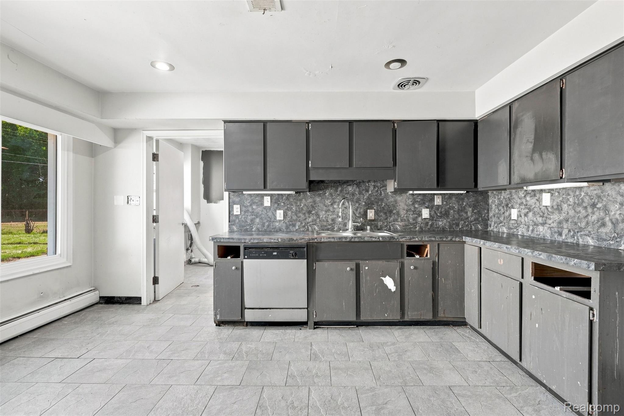 17620 Cornell Road Southfield, MI 48075 - Photo 9 of 29 Kitchen featuring dark cabinetry, patterned countertops and backsplash, stainless steel dishwasher, and recessed lighting