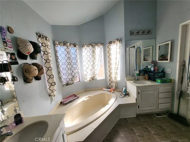 a spacious bathroom with a tub sink and mirror