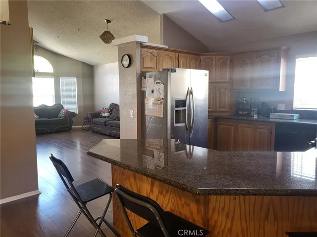a kitchen with granite countertop a table chairs microwave and sink