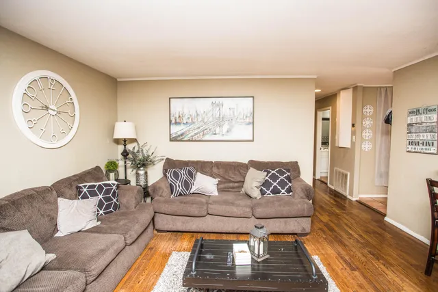 a living room with furniture and a wooden floor