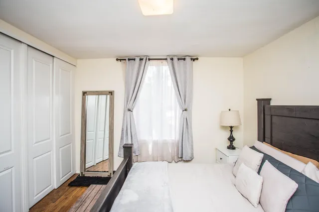 a bedroom with a bed and a large window