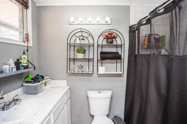 a bathroom with a toilet sink and mirror
