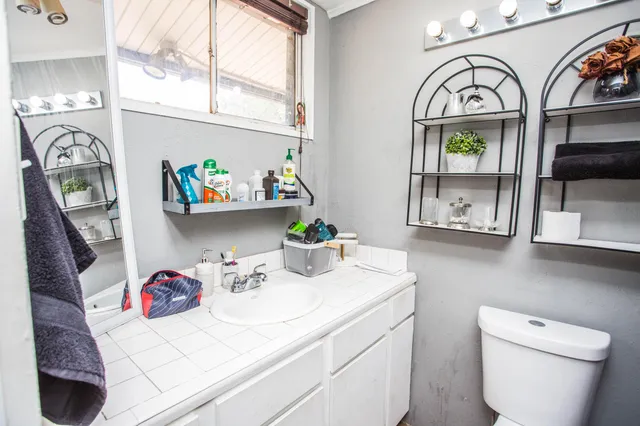 a bathroom with a sink mirror vanity and toilet