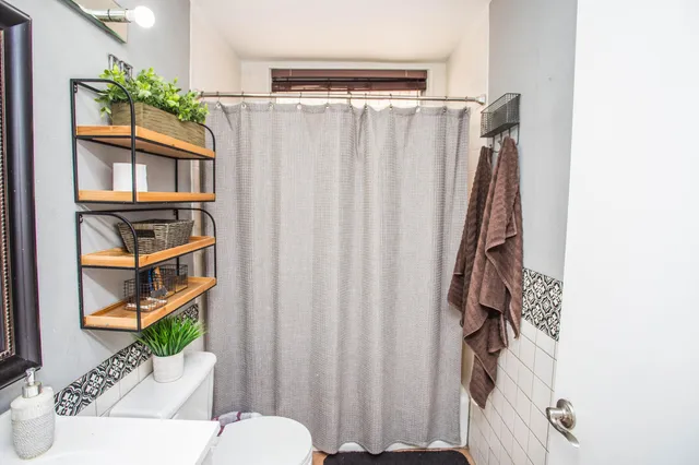 a bathroom with a sink toilet and shower curtain